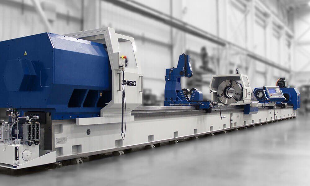 A large blue and white machine is sitting in a factory.