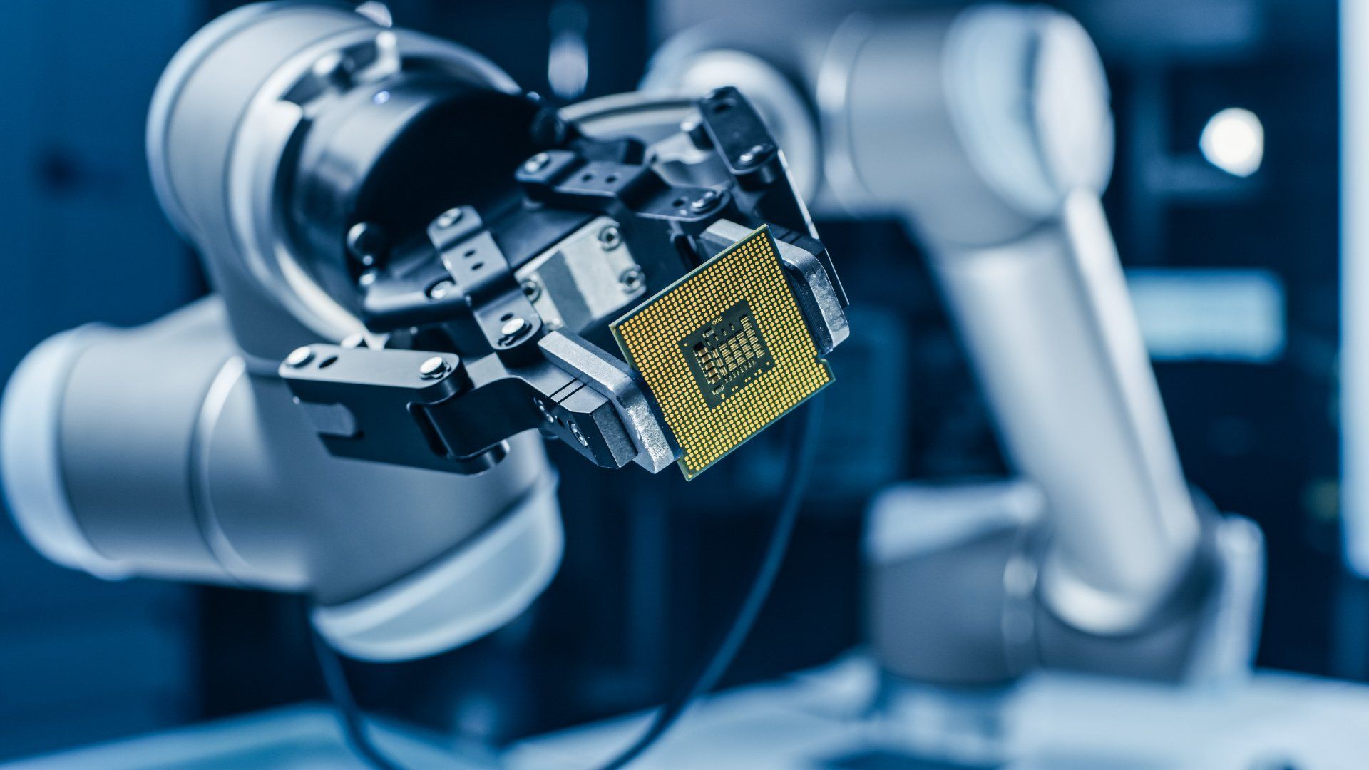 A robotic arm is holding a chip in its hand.